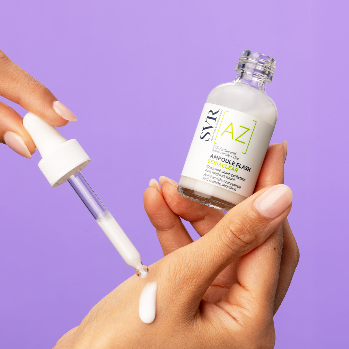 Szklana butelka serum SVR Sebiaclear Ampoule AZ z pipetą aplikującą mleczny preparat na dłoń na fioletowym tle.